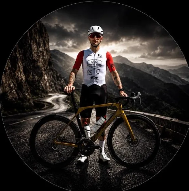 Corredor del equipo Madma Bikes con su bicicleta en un puerto de montaña