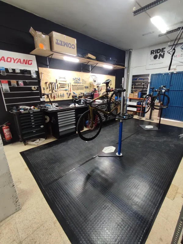 Taller de Madma Bikes con bicicleta en el soporte de trabajo